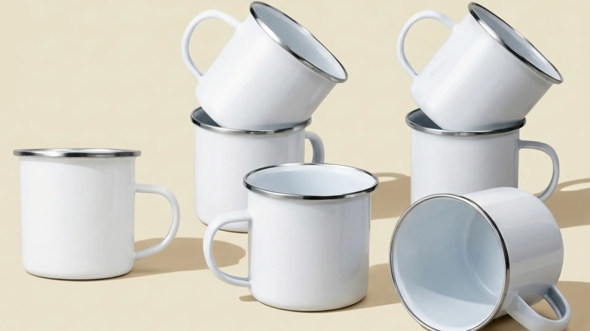 Tazas de peltre blancas apiladas sobre fondo crema